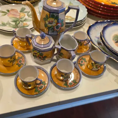 Vintage Japanese lusterware tea set featuring a teapot, sugar bowl, creamer, and matching cups and saucers with hand-painted floral motifs.