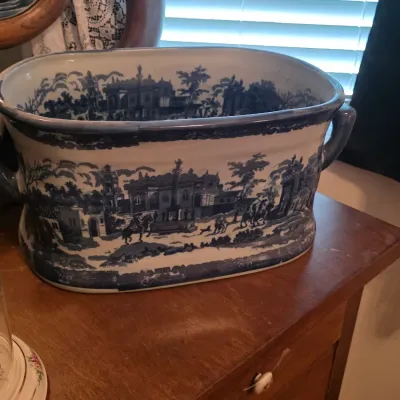 Vintage blue and white transferware footbath planter featuring a detailed landscape scene with buildings and figures.