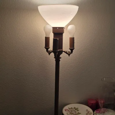 Vintage metal floor lamp featuring a central milk glass torchiere shade and two flanking candle-style sockets, shown illuminated.