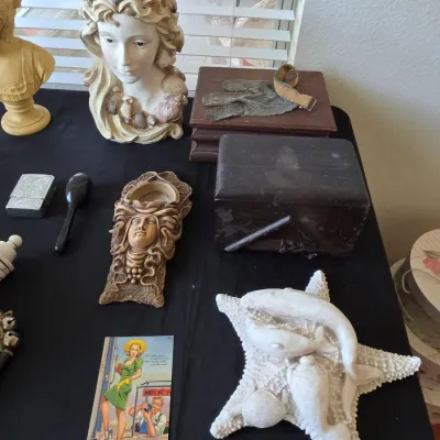 Assortment of vintage collectibles, including a female bust with seashell hair, a carved wall pocket, a vintage postcard, and a...