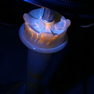 Vintage slag glass lamp base showing a bright orange fluorescence under a UV blacklight.