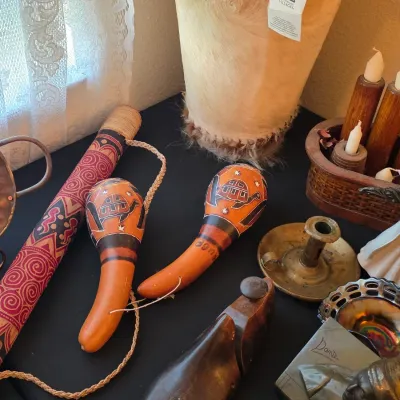 Assortment of vintage and global decor, including hand-painted gourd maracas with turtle motifs, a patterned rainstick, a hide-covered...
