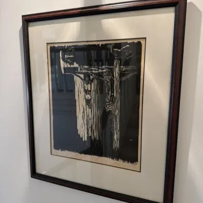 Sale Photo Thumbnail #120: Framed black and white woodcut print depicting a crucifixion scene, signed and titled in pencil along the bottom margin.