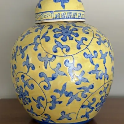 Sale Photo Thumbnail #112: Chinese ginger jar with a yellow ground and blue floral scroll motif, featuring a matching domed lid with Chinese characters along the rim.