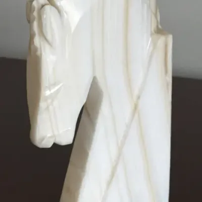 Carved white and tan onyx horse head sculpture, featuring a stylized profile with a polished finish.