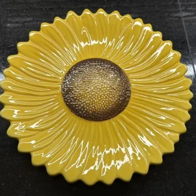 Vibrant yellow ceramic sunflower serving platter with a textured brown center, showing a glossy finish.