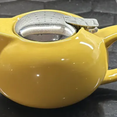 Forlife yellow ceramic teapot featuring a stainless steel flip-top lid and built-in infuser.