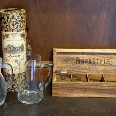 NapaStyle wooden storage box with compartments, paired with two clear glass pitchers and a decorative Savigny wine cylinder container.