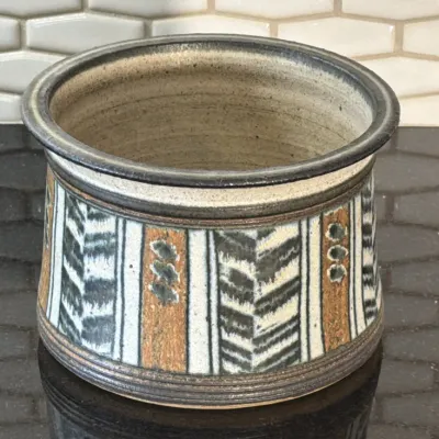 Studio art pottery planter or crock featuring hand-painted geometric chevron and stripe patterns in earth tones.