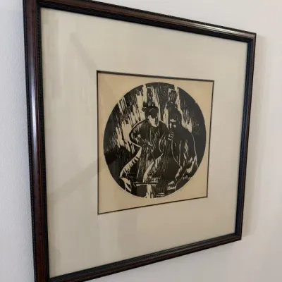 Sale Photo Thumbnail #119: Framed black and white woodcut print depicting two musicians playing double basses, presented in a dark wood frame with a wide cream mat.