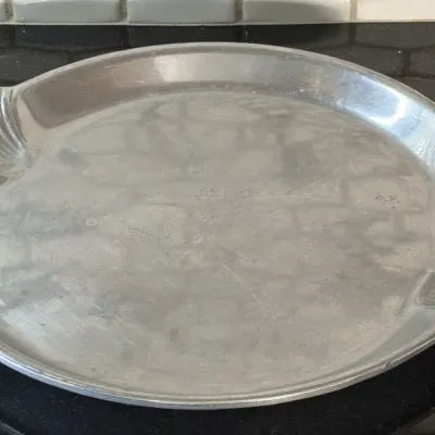 Vintage Arthur Court aluminum serving platter featuring a round design with scalloped shell-motif handles.