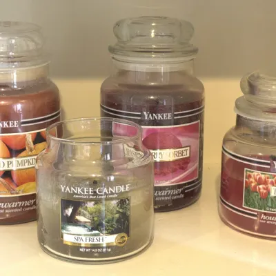 Four vintage Yankee Candle Housewarmer scented jar candles, including Spiced Pumpkin, Raspberry Sorbet, Tulips, and Spa Fresh.