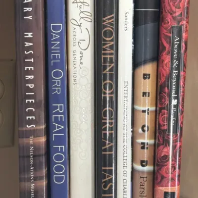 Collection of seven hardcover cookbooks and culinary art books, including titles from museum and junior league organizations, showing...