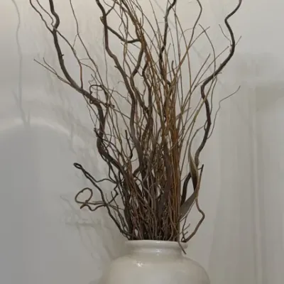 Sale Photo Thumbnail #117: Large white ceramic floor vase filled with decorative curly willow branches.