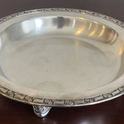 Vintage footed silverplate serving dish featuring an embossed floral and scroll border.