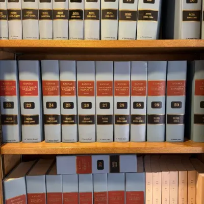 Sale Photo Thumbnail #122: Collection of Kansas Court of Appeals Reports law books, volumes 11 through 39, housed on wooden bookshelves.