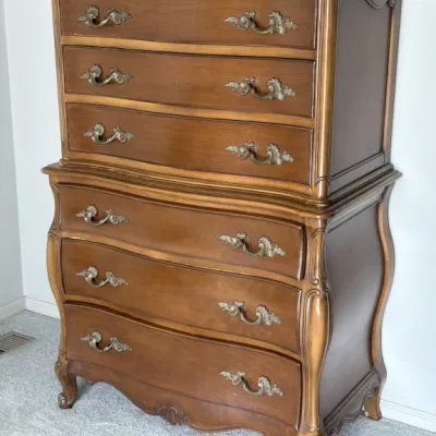 Sale Photo Thumbnail #105: French Provincial style chest-on-chest dresser in a warm wood finish, featuring six drawers with ornate brass pulls and elegant cabriole legs.