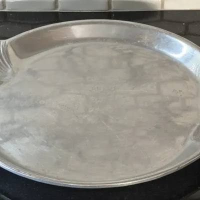 Vintage Arthur Court cast aluminum serving platter featuring scalloped shell handles, showing light surface wear.