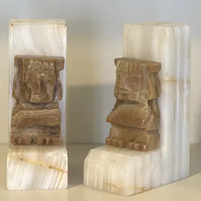 Pair of vintage carved onyx bookends featuring stylized Aztec or Mayan figures on L-shaped bases.