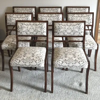Set of eight mahogany dining chairs featuring a classic Neoclassical style with upholstered seats and backs in a grey and white damask...