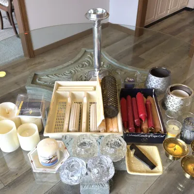 Assortment of candles and candle holders, including pillar candles, Colonial Candle of Cape Cod taper candles, glass votive holders, and...