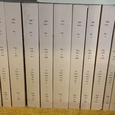 Sale Photo Thumbnail #123: Collection of vintage Kansas Reports and Kansas Court of Appeals law books with white spines, showing volume and page numbers.