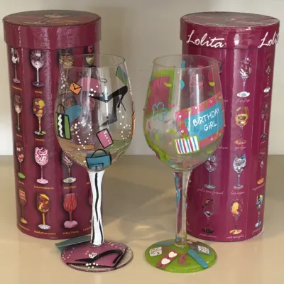 Two Lolita hand-painted wine glasses, including a shopping-themed design and a "Birthday Girl" design, each with its original...