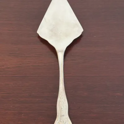 Vintage silver-plated pie or cake server featuring an ornate shell motif on the handle.