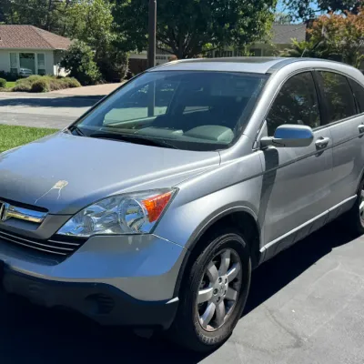Silver third-generation Honda CR-V crossover SUV, showing some minor paint wear on the hood.