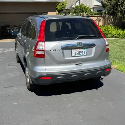 Silver Honda CR-V crossover SUV, third generation (circa 2007-2011), parked in a driveway.