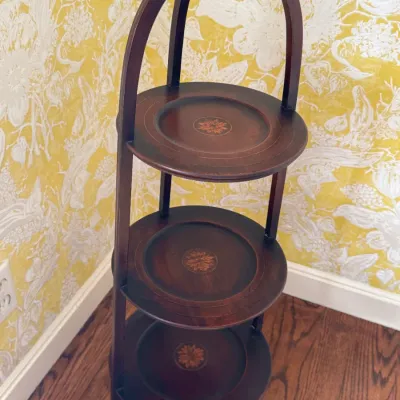 Vintage three-tier wooden muffin stand featuring inlaid floral medallions on each shelf and an arched carrying handle.