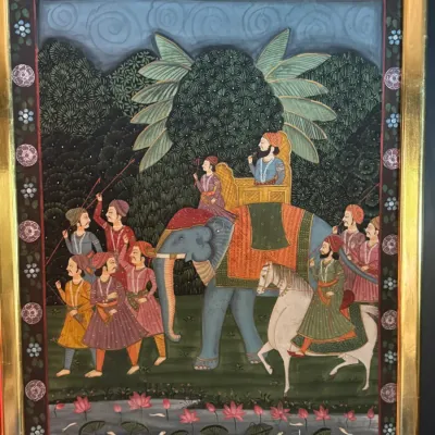 Indian miniature painting depicting a royal procession with figures riding an elephant and a horse, housed in a gilded frame.