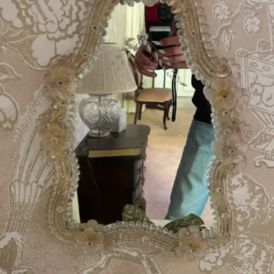 Vintage Venetian Murano glass mirror featuring an ornate, scalloped frame adorned with delicate glass flowers and gold-flecked accents.
