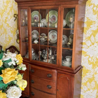 Traditional cherry wood china cabinet featuring a glass-front upper hutch with muntin details and a lower buffet base with three...