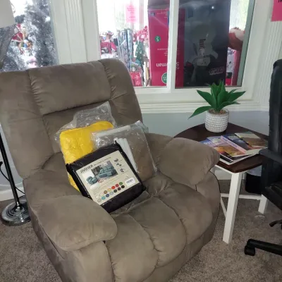 Plush brown microfiber recliner chair holding a packaged Jiviner recliner slipcover and a yellow cushion, positioned next to a small side...