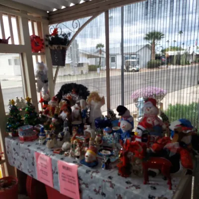 A collection of vintage Christmas decorations, including snowmen, Santa figurines, and miniature trees, displayed on a table at an...