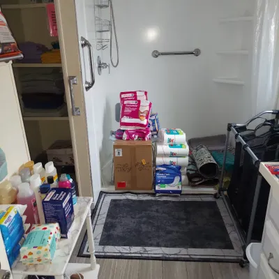 Assorted household and personal care items, including toilet paper, adult diapers, and toiletries, displayed in a bathroom setting.