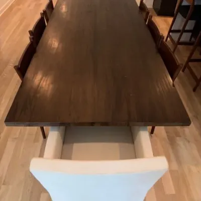 Dark wood plank dining table with RH Ellison upholstered end chair