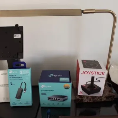 Brass desk lamp, TP-Link network switch, tech accessories