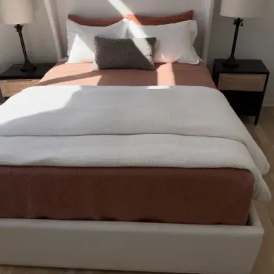 Upholstered white platform bed with cane nightstands