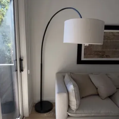 Black arc floor lamp with white drum shade