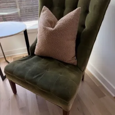 Green velvet tufted slipper chair with pillow