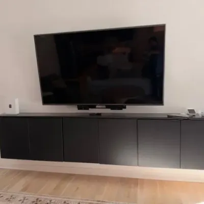 IKEA BESTÅ black wall-mounted media console and flat-screen TV