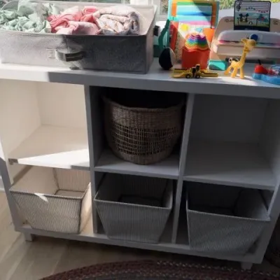 White cube storage shelf with bins and kids toys