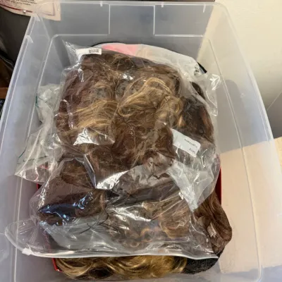 Assorted Hair Extensions and Wigs in Storage Bin
