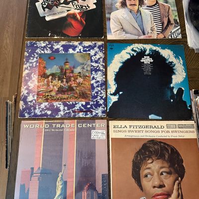 Collection of vintage vinyl records and a calendar, including Judas Priest's "British Steel," Simon and Garfunkel's...
