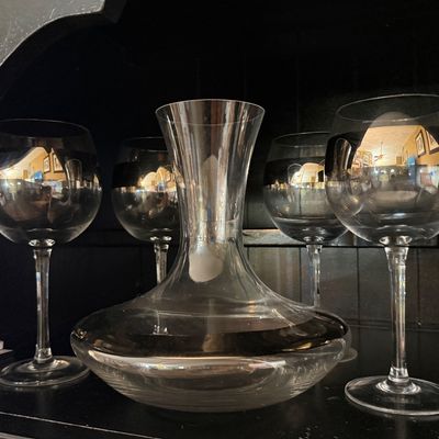 Mid-century modern silver-rimmed glass decanter set, including a wide-bottomed decanter and four matching stemmed wine glasses.
