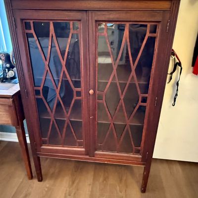 Vintage mahogany display cabinet featuring double glass doors with elegant diamond-patterned wood mullions and interior shelving.