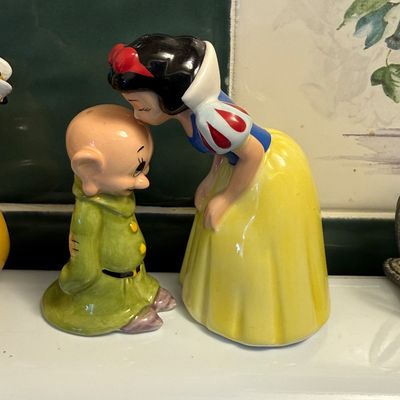 Vintage Goebel Disney ceramic figurines depicting Snow White kissing Dopey on the head, featuring a glossy finish and vibrant colors.