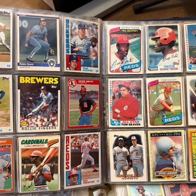 Collection of vintage baseball and football trading cards from the late 1970s and early 1980s, including Topps and Fleer brands, housed...